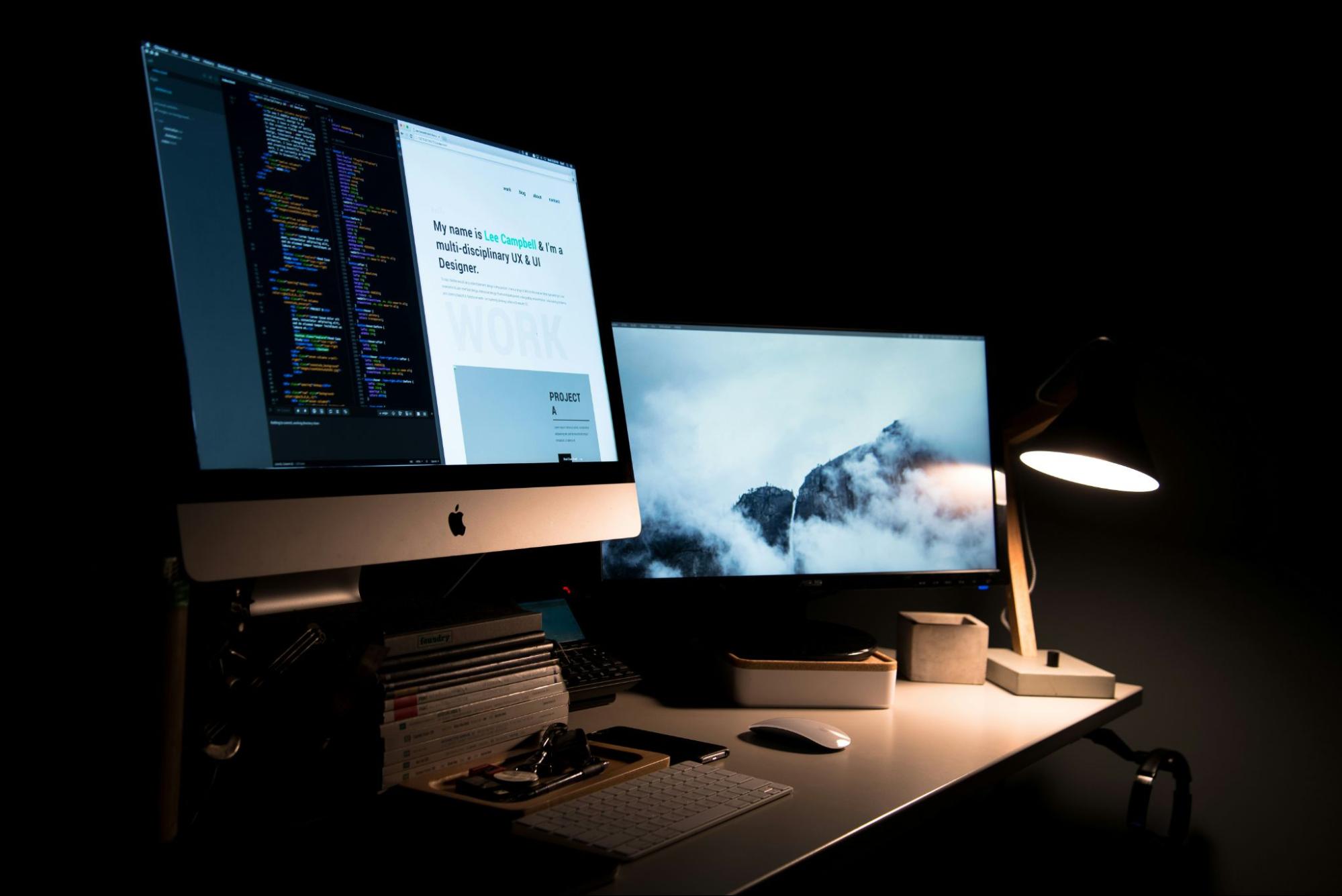 image of two desktop computers in dimly lit room