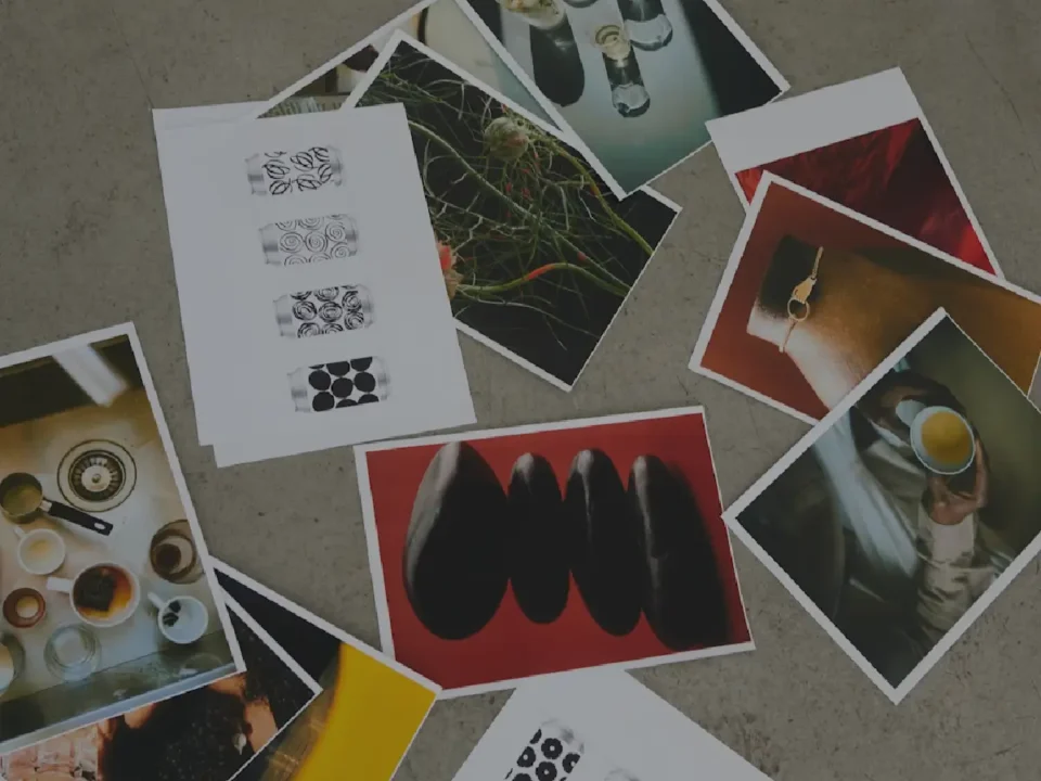 Scattered printed photographs on a concrete floor showcasing various creative product and lifestyle shots